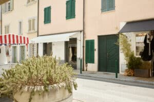 Street in central Forte dei Marmi with pastel facades, green shutters and shop awnings