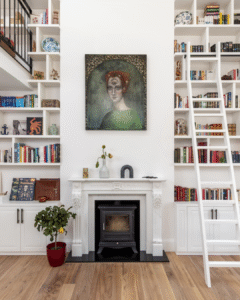 A double-height Victorian living space with full-height bookshelves, mezzanine walkway, and natural light — showcasing sensory architecture at 56CG.