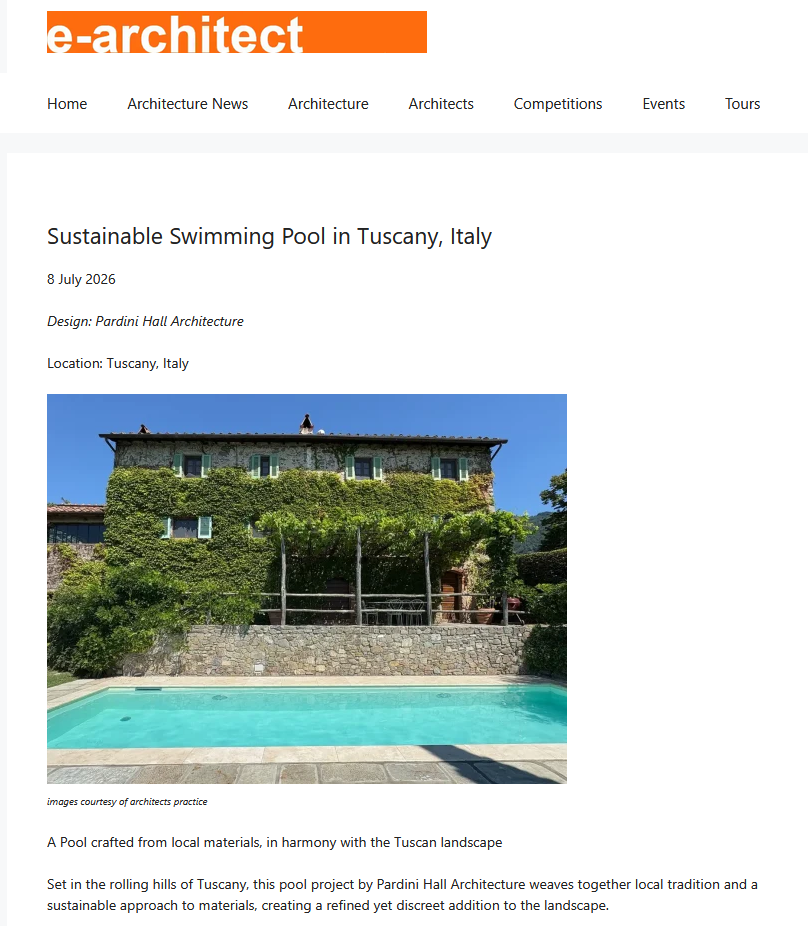 Ivy-covered Tuscan villa overlooking a turquoise rectangular pool with a stone terrace in the foreground